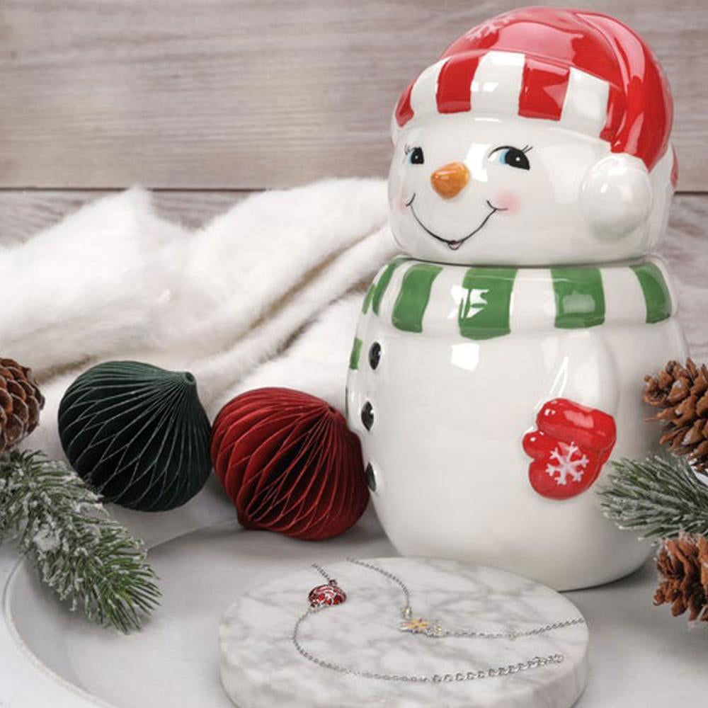 Frosty Jewel Candle - festliche Schneemann-Duftkerze mit roter Mütze und grünem Schal, dekoriert mit Weihnachtskugeln, Tannenzweigen und Schmuck-Armband als Überraschung.